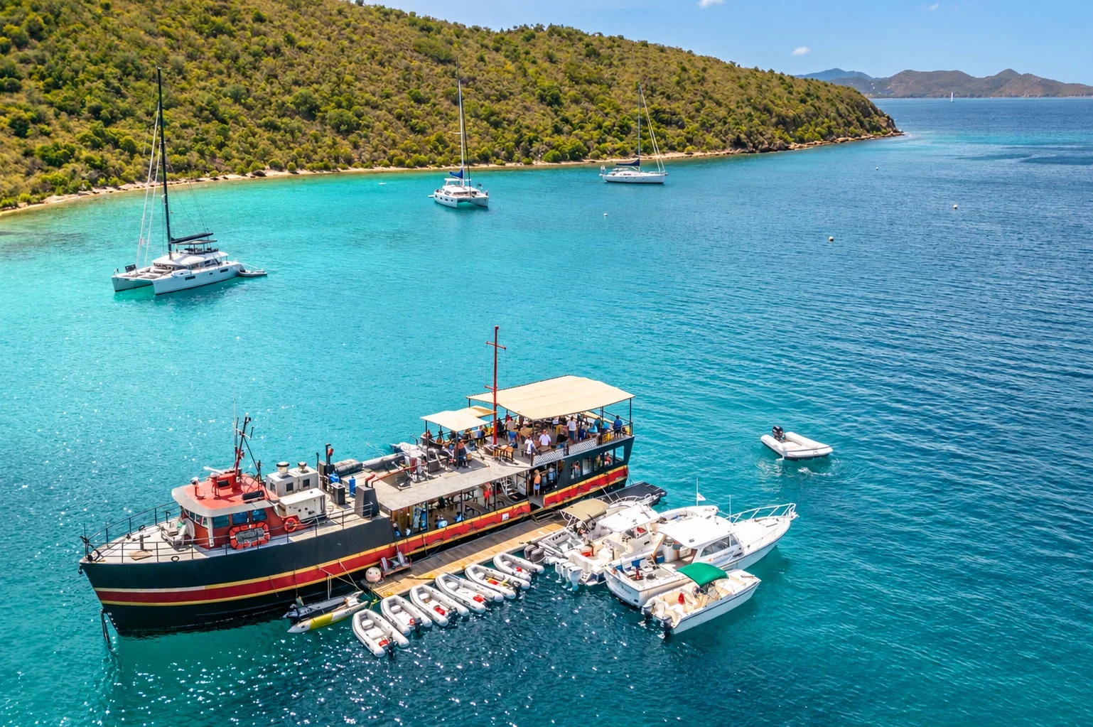 Aerial view of the Willy T floating bar with dinghies tied alongside